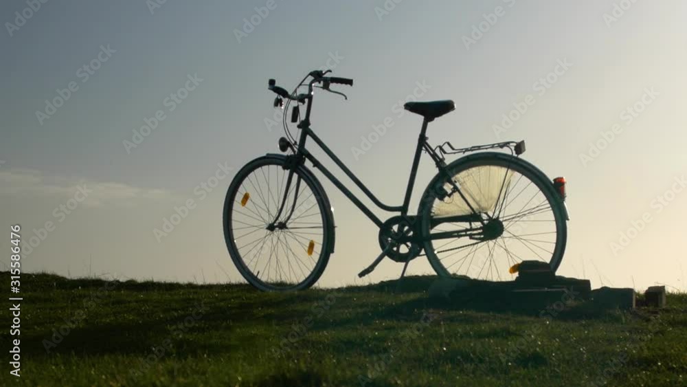 A bike is standing on a field, blue sky is in the background. A bike is standing on a field, blue sky is in the background.