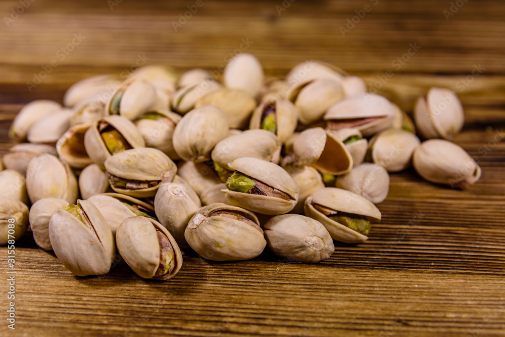 Pile of pistachio nuts on a wooden table