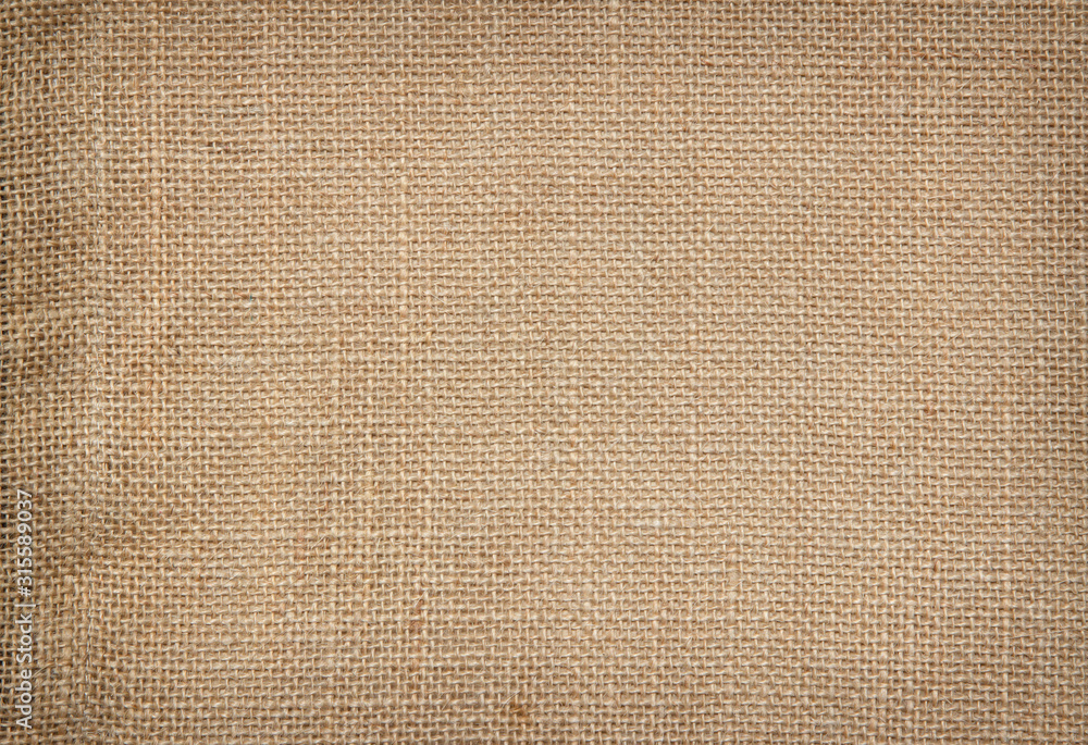 Fototapeta premium Brown Hemp rope texture background. Sackcloth or blanket wale linen wallpaper. Rustic sack canvas fabric texture in natural. Haircloth vintage linen burlap weaving, Old beige carpet background.
