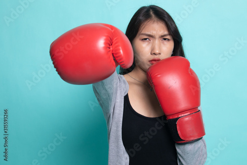 Young Asian woman with red boxing gloves. © halfbottle