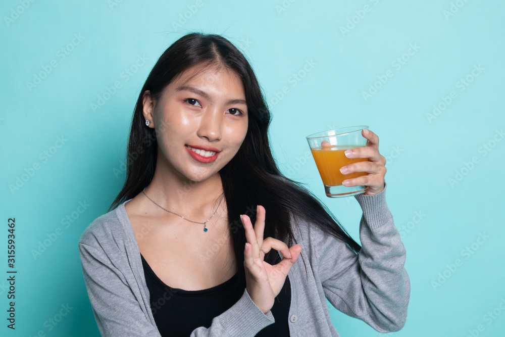 Young Asian woman show OK drink orange juice. Young Asian woman show OK drink orange juice.