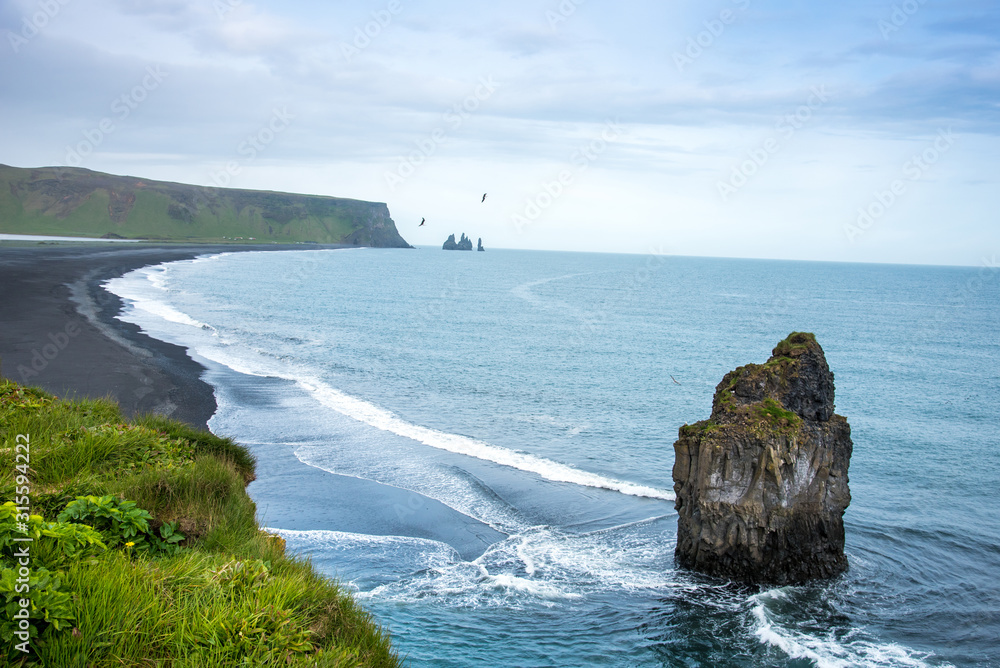 Magical amazing dramatic scenic landscape with big alone stone in the middle of the ocean nearby Reynisdrangar Sea Cliffs, near cape Dyrholaey and Vik, Iceland. Exotic countries. Amazing places.