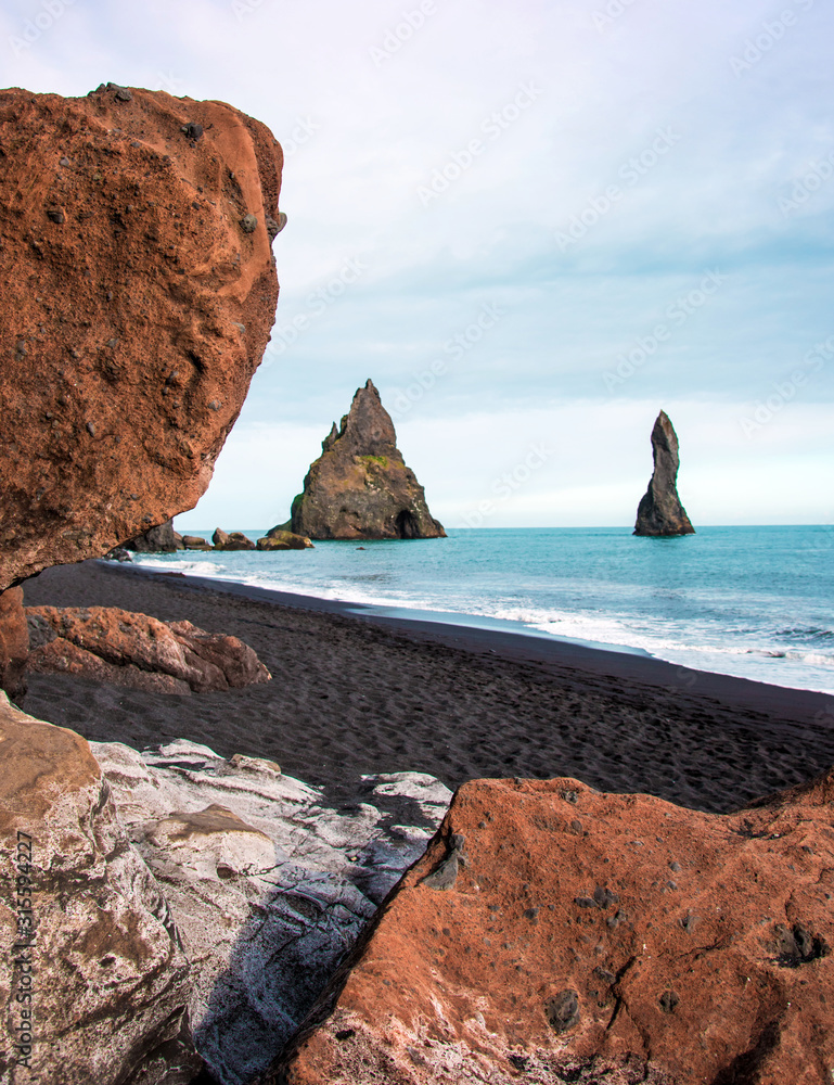 Magical majestic dramatic landscape with Reynisdrangar Sea Cliffs, stones called Troll under the Reynisfjall Mountain near Vik, Iceland. Exotic countries.