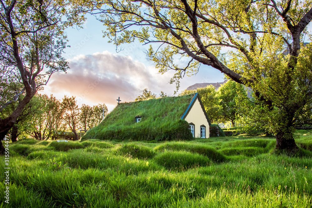 Charming mystical scene with turf roof church in old Iceland traditional style and mystical cemetery in Hof, Skaftafell, Vatnajokull National Park. Exotic countries.