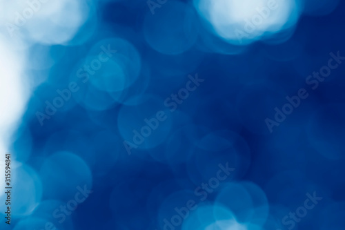 image of a yellow summer blur background toned in trendy Classic Blue color of the Year 2020