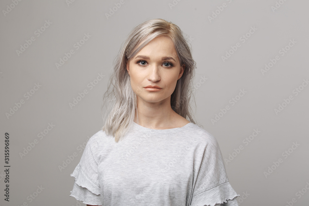 Fototapeta premium Cute young woman in the white clothes posing in the studio