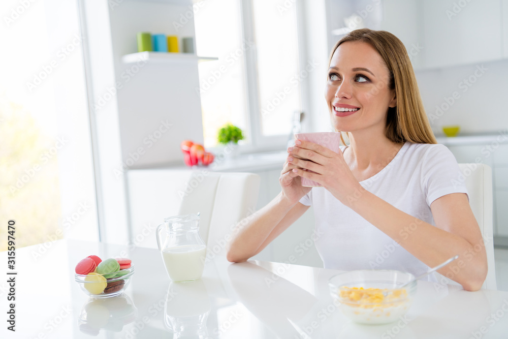 Photo of dreamer housewife holding hot beverage breakfast cornflakes healthy eating dieting looking dreamy imagine herself chin sitting table white light kitchen indoors Photo of dreamer housewife holding hot beverage breakfast cornflakes healthy eating dieting looking dreamy imagine herself chin sitting table white light kitchen indoors
