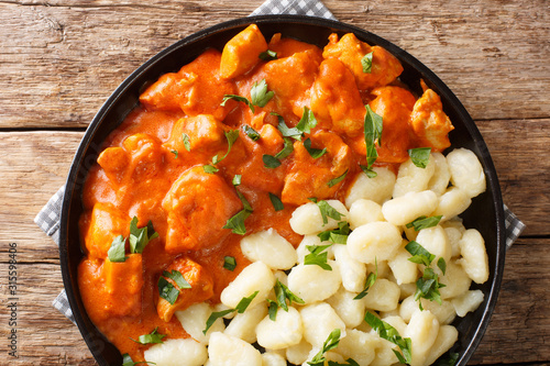 tender pieces of chicken in a fragrant creamy sauce, this Chicken Paprikash closeup on a plate. Horizontal top view photo