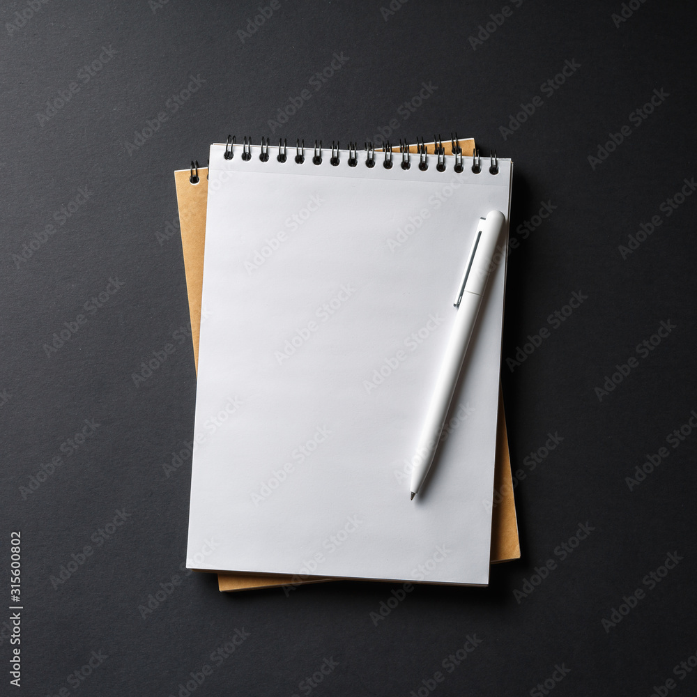 notebook with white pen on black background