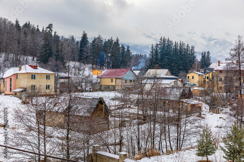 Snow-covered houses in the village of Bakuriani on a background of mountains