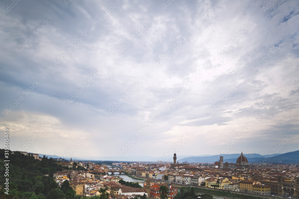 Beautiful bird's-eye view of Florence and the Arno river. Cloudy sky. Travel background.