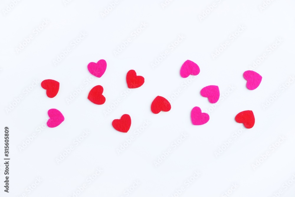Red and pink felt hearts on a white background. Valentine's day symbol, holiday concept. Top view with copy space for text.