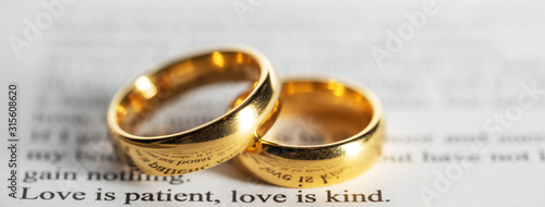 Golden wedding rings on bible book photo