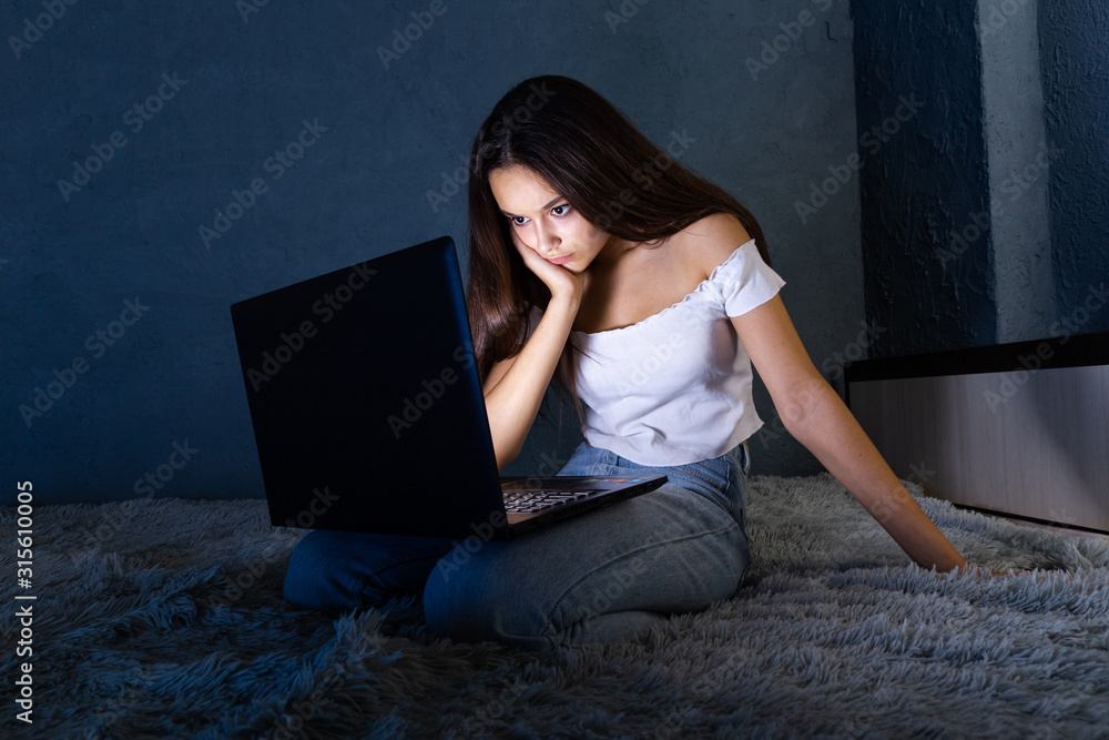 sad and female teenager with tablet computer and laptop suffering cyberbullying and harassment being online abused by stalker or gossip feeling desperate and humiliated in cyber bullying sad and female teenager with tablet computer and laptop suffering cyberbullying and harassment being online abused by stalker or gossip feeling desperate and humiliated in cyber bullying