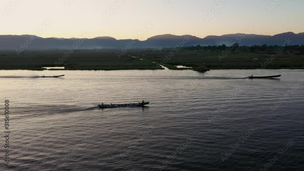 Various boats moving down Inle Lake in Myanmar on a calm afternoon Various boats moving down Inle Lake in Myanmar on a calm afternoon