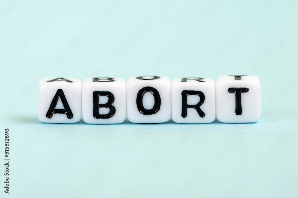Abort word written on cubes. Medical blue background Abort word written on cubes. Medical blue background