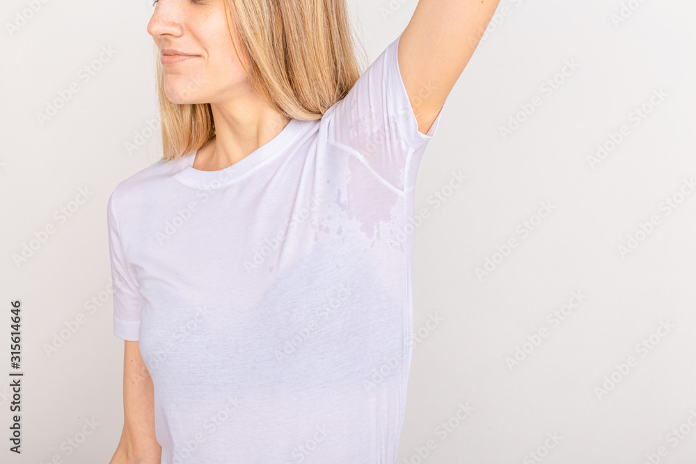 Close-up asian woman with hyperhidrosis sweating. Young asia woman with sweat stain on her clothes against grey background. Healthcare concept. Close-up asian woman with hyperhidrosis sweating. Young asia woman with sweat stain on her clothes against grey background. Healthcare concept.