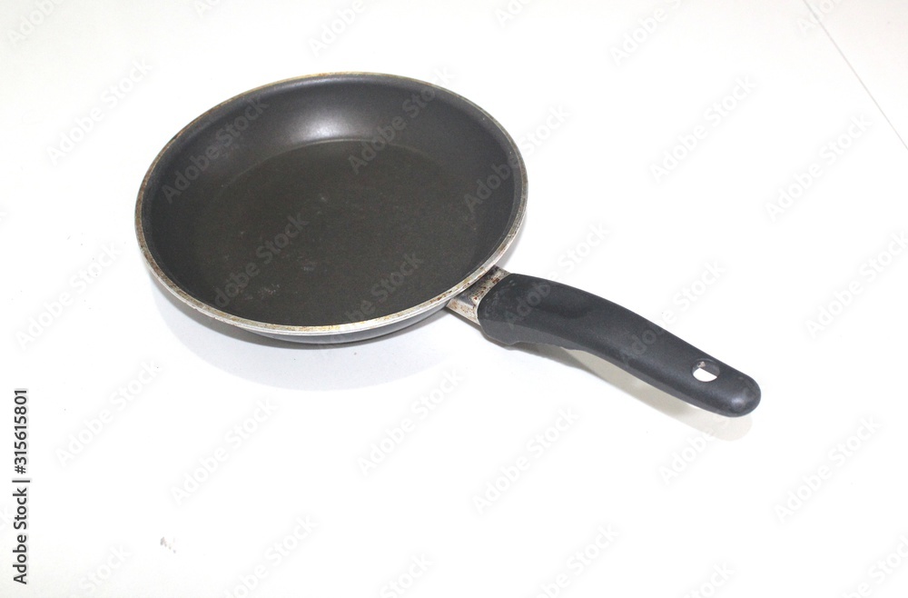 an old frying pan with teflon surface isolated on white background an old frying pan with teflon surface isolated on white background