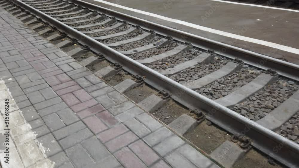 A point of view of a person who walks along a railway platform and looks at the rails. A point of view of a person who walks along a railway platform and looks at the rails.