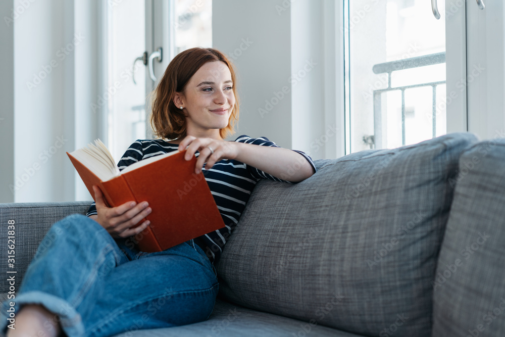 Casual trendy young woman relaxing with a book Casual trendy young woman relaxing with a book