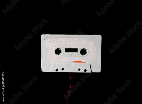 Leeds, UK, 03/02/19Cassette unspooled with loose tape tangled up around itself shot on isolated on a white background professionally with studio lighting and old retro vintage media unused now