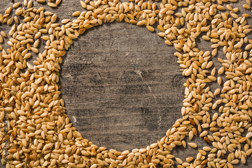 Golden flax seeds on wooden table. Copy space