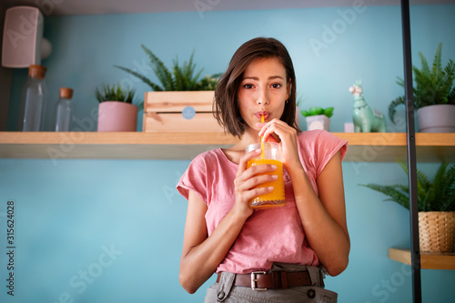 Young beautiful woman enjoying a healthy raw fruit juice.