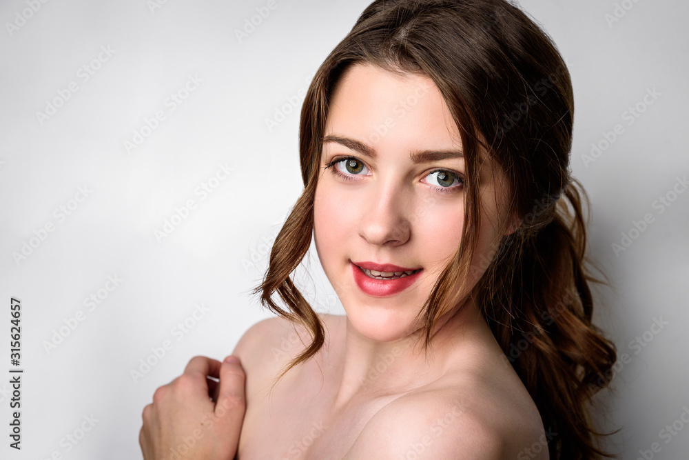 Fototapeta premium Beauty portrait of female face with natural skin on gray background.