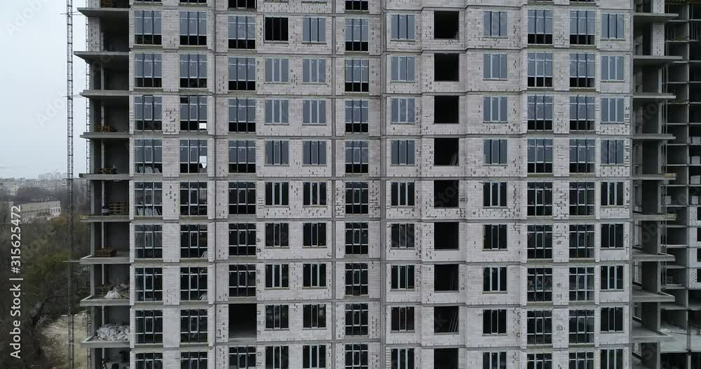 Aerial view on construction of multi-storey residential building in the city. Construction site of high-rise building. Foundation of multi-storey building. Residential building under construction Aerial view on construction of multi-storey residential building in the city. Construction site of high-rise building. Foundation of multi-storey building. Residential building under construction