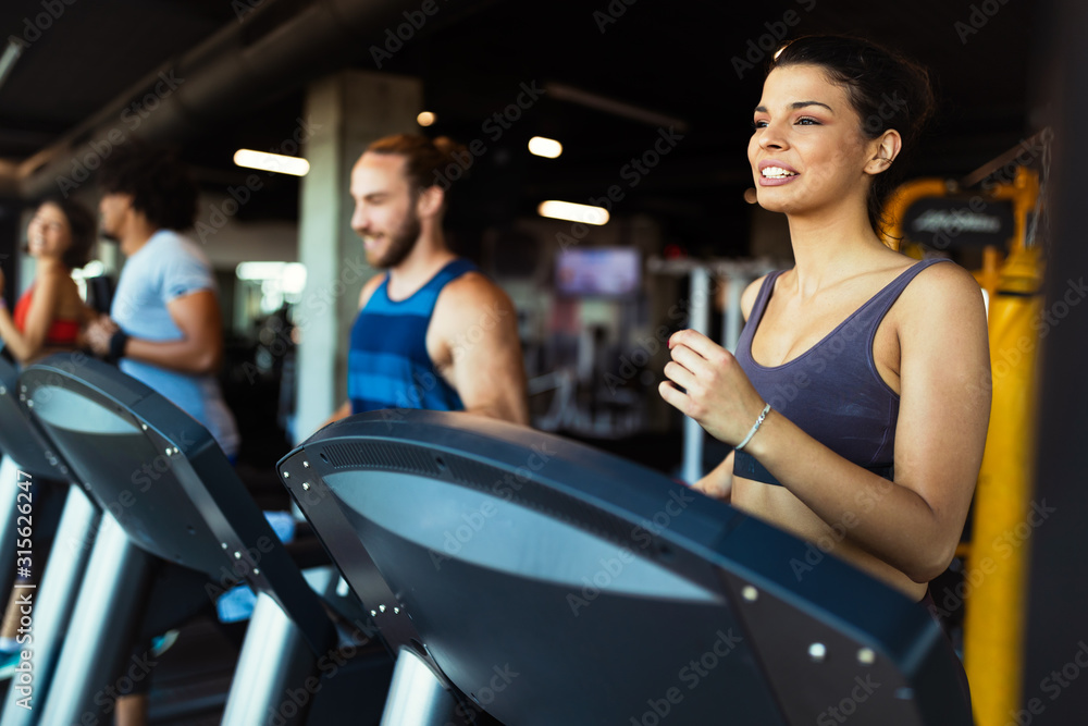 Happy fit friends exercising, working out in gym to stay healthy together Happy fit friends exercising, working out in gym to stay healthy together