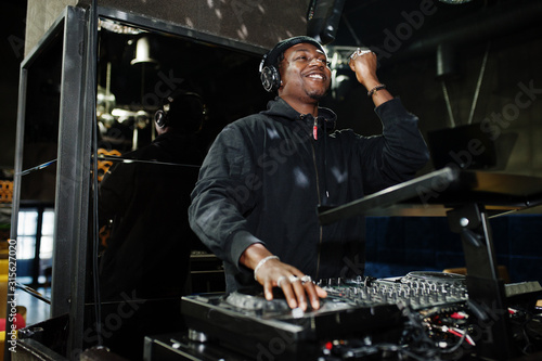 Fotografie African american dj play music on decks at night club.