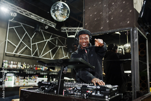 Fotografie African american dj play music on decks at night club.