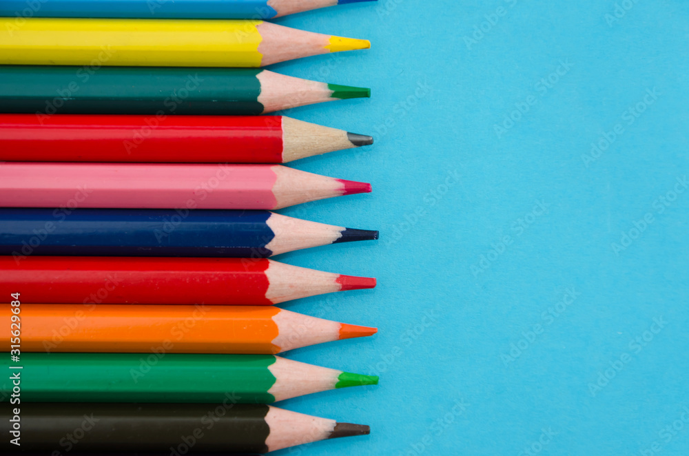 Fototapeta premium colored pencils on blue background. Close-up. Place for text.