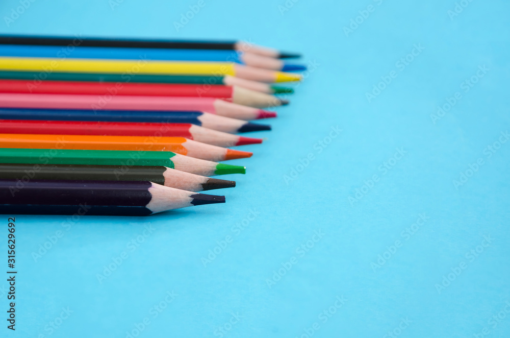 Fototapeta premium colored pencils on blue background. Close-up. Place for text.