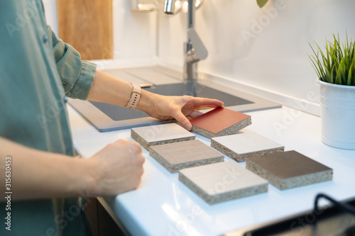 Canvas Print woman choosing kitchen countertop material texture from samples
