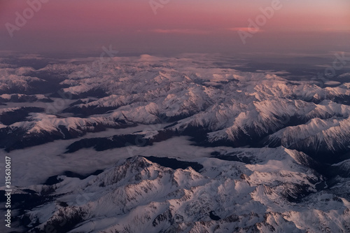 Shot of snow covered Pyrénées mountains in the south of France taken from the airplane window at sunset