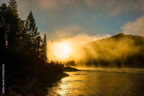 Golden fog over the siberian mountain river Small Yenisei in early summer morning. photo