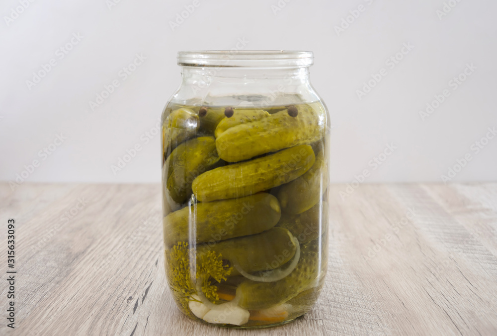 jar of pickled cucumbers on a wooden background. Homemade pickles. jar of pickled cucumbers on a wooden background. Homemade pickles.