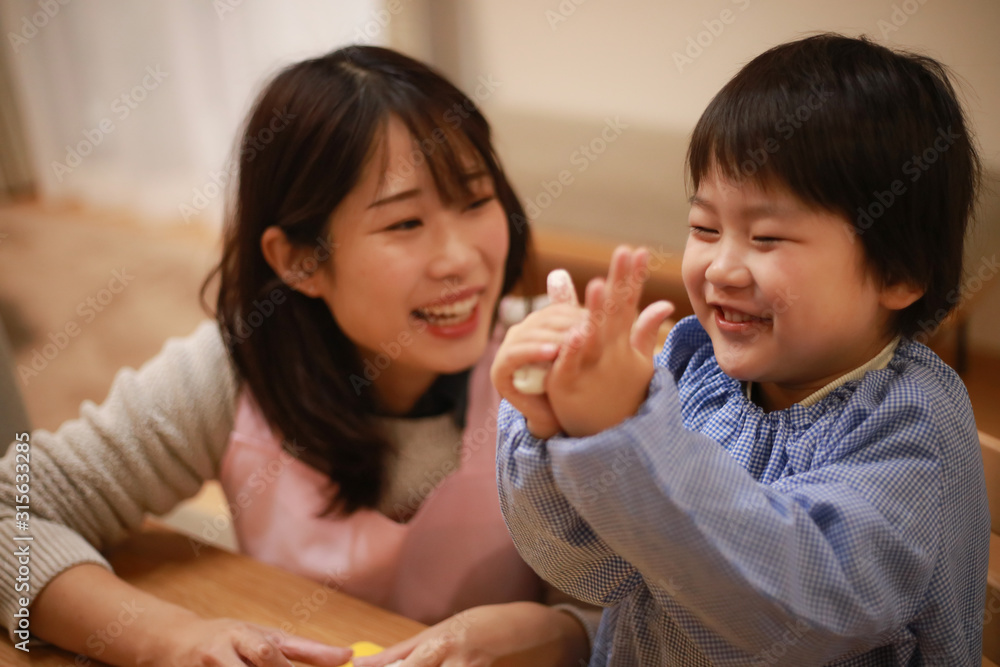 ねんどで遊ぶ男の子と保育士イメージ