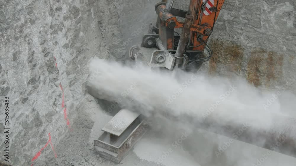 Horizontal drilling into limestone rock with hydraulic drill rig Stock