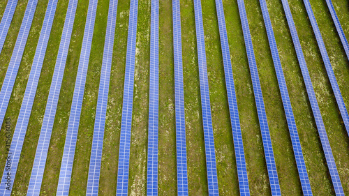 aerial view of solar panels on green lawn. drone shot, bird's eye