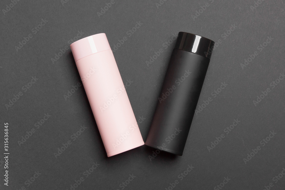 black and pink thermos cup on black colored paper background black and pink thermos cup on black colored paper background