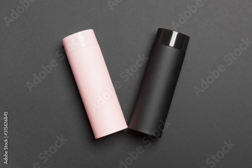 black and pink thermos cup on black colored paper background