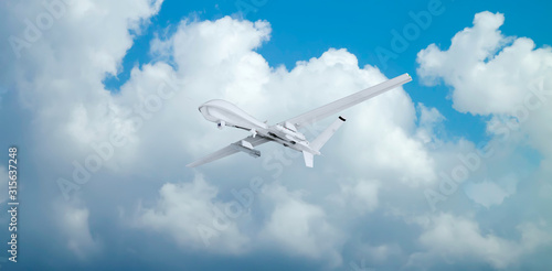 military RC drone flies against backdrop of beautiful clouds on blue sky background.