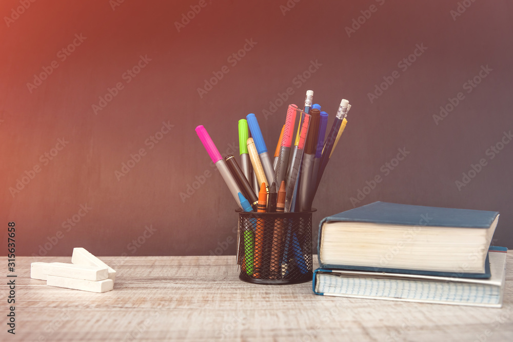 empty notepad on teacher desk against chalkboard. education concept empty notepad on teacher desk against chalkboard. education concept