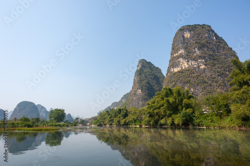 Lake with limestone karst hills foggy landscape reflecting in the river in Yangshuo, Guangxi province, China