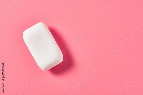 One whole antibacterial and anti allergic aromatic soap lies on pink countertop in bathroom or spa salon. Space for text. Top view