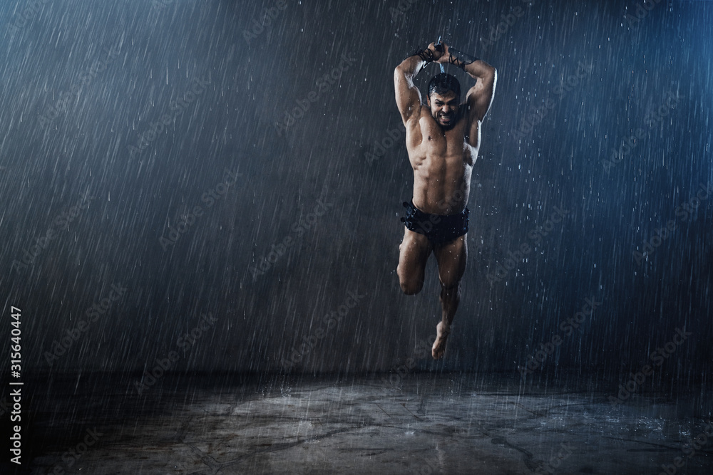Wet shirtless gladiator jumping in attack.