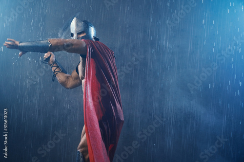 Muscular spartan in red cloak attacking.