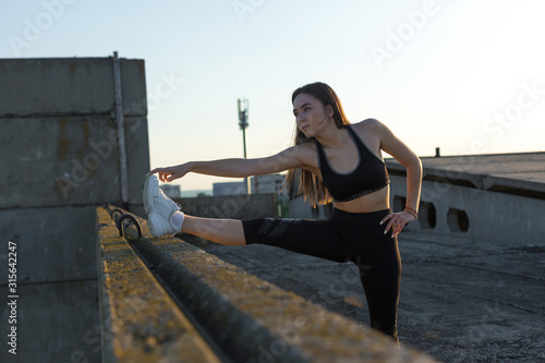 A young slim athletic girl in sportswear with snakeskin prints performs a set of exercises. Fitness and healthy lifestyle.